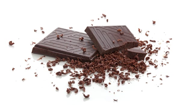 Pieces of chocolate bar with crumbs and cjips on the white background