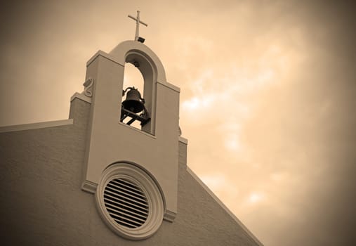 sepia cross and bell on christian church