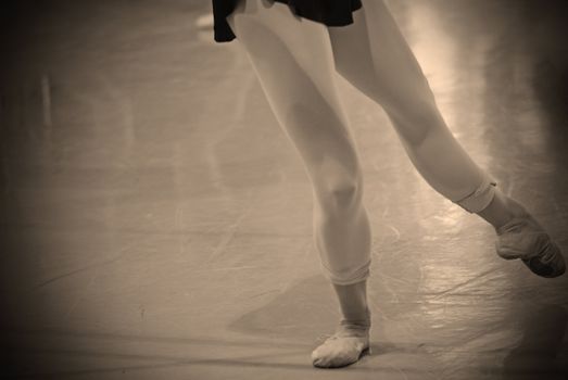 woman's legs practicing ballet in a studio