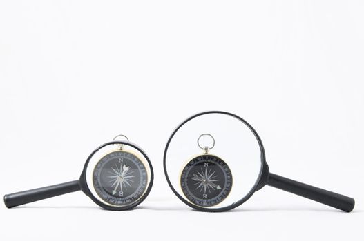 Orientation Concept Magnify Glass and Compass on a White Background