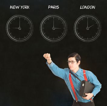 Nerd geek businessman with chalk time difference clocks on blackboard background