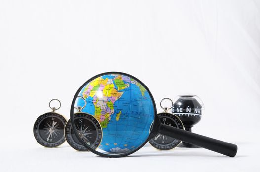 Orientation Concept Earth,Magnify Glass and Compass on a White Background