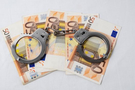 Financial Concept Handcuffs and Money on a White Background