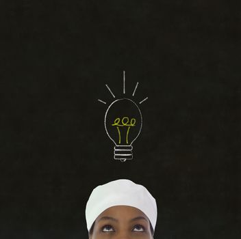 Bright idea lightbulb thinking African or African American woman chef on chalk blackboard background