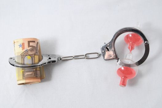 Financial Concept Handcuffs and Money on a White Background