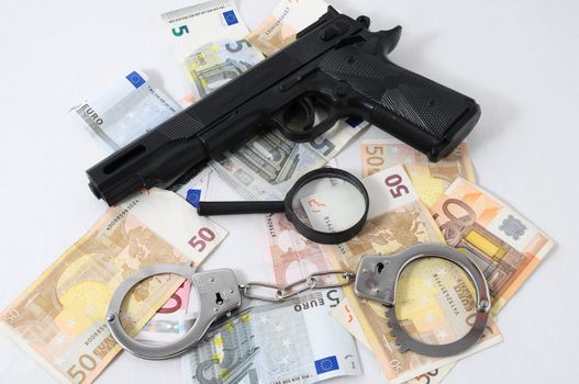 Financial Concept Handcuffs, Gun and Money on a White Background
