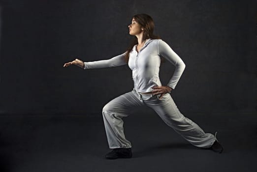 Young woman posing against gray concrete wall