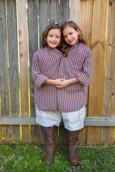 twin girls fancy dressed up pretending be siamese with his father shirt