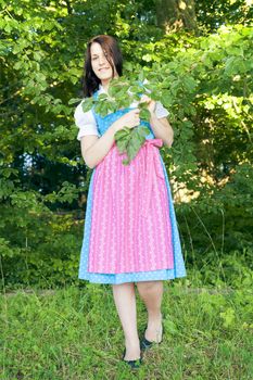 A woman in bavarian traditional dirndl in the nature