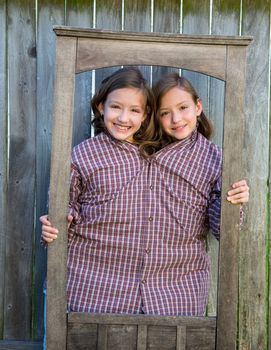 twin girls fancy dressed up pretending be siamese with dad shirt playing with grunge border frame
