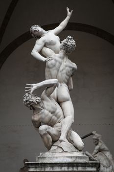 Florence, Italy – July 11, 2013: The Rape of Sabine Women sculpture by Giambologna, in the Loggia dei Lanzi building, located on a corner of Piazza della Signoria square in Florence, Italy.