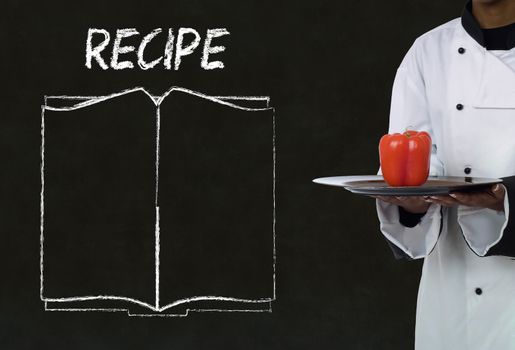 Chef with recipe book on chalk blackboard menu writing background