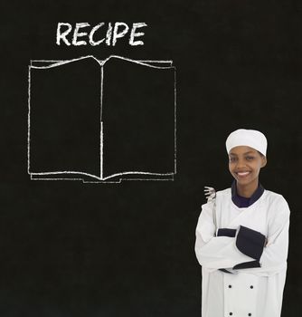 Chef with recipe book on chalk blackboard menu writing background