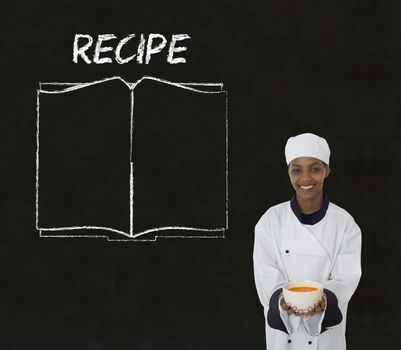 Chef with recipe book on chalk blackboard menu writing background