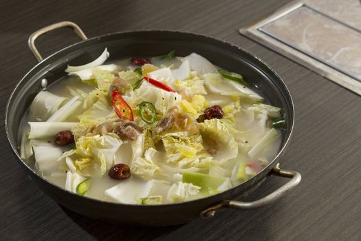 A heated wok of korean stew with boiled cartilage, cabbage, spring onion - Dogani Jeongol