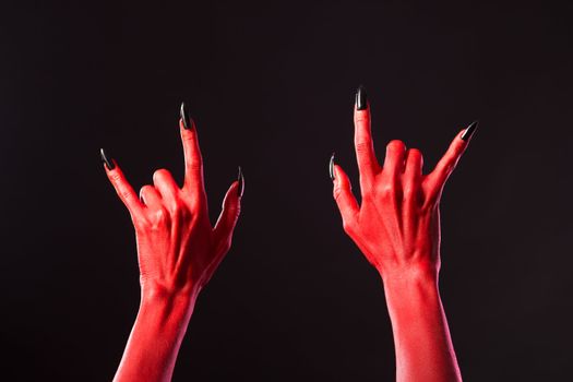 Red devil hands showing heavy metal, Halloween or music theme 