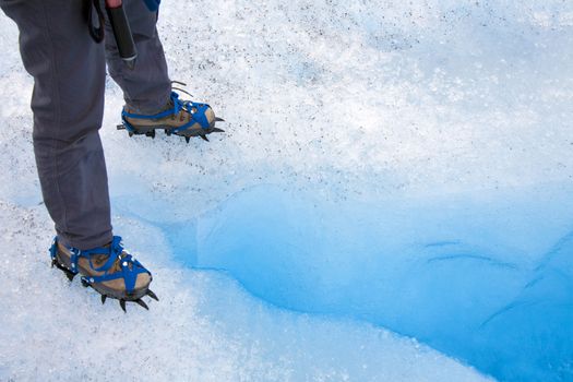 Standing over a crevasse on the Perito Moreno Glacier in the Andes Mountains of Patagonia in southern Argentina.