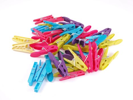 Multicoloured plastic clothes pegs on a white background.