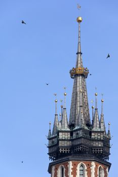 The fine medieval Gothic Bell Tower on the spire of the Church of St. Mary in the Market Square of the 'Old Town' in Krakow in Poland. Also known as the Church of the Assumption of the Virgin. 