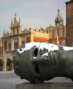 The sculpture 'Eros Bound' by Igor Mitoraj by the Cloth Hall in the Market Square (Rynek Glowny) in Krakow in Poland.  
