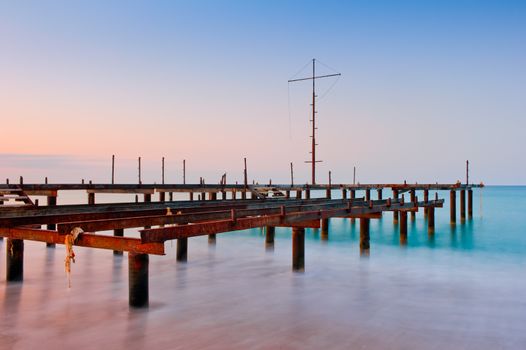 Old pier in the sea at dawn