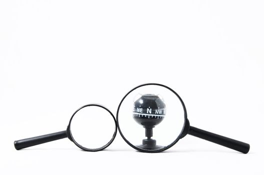 Orientation Concept Magnify Glass and Compass on a White Background