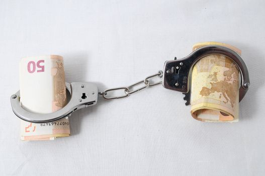 Financial Concept Handcuffs and Money on a White Background