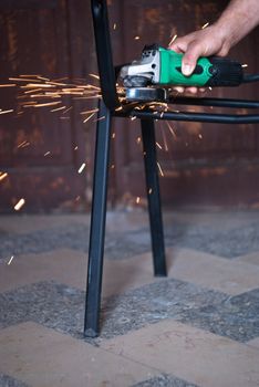 Worker cutting metal using angular grinding machine