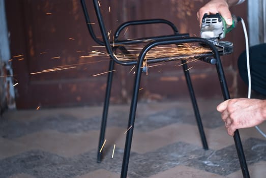 Worker cutting metal using angular grinding machine