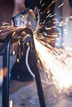 Worker cutting metal using angular grinding machine