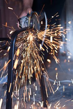 Worker cutting metal using angular grinding machine