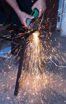 Worker cutting metal using angular grinding machine