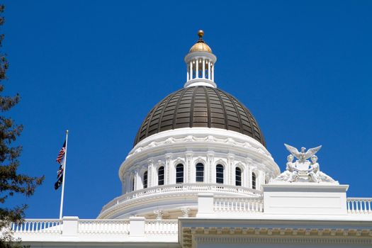 California statehouse dome showing architectural details against a blue sky background.