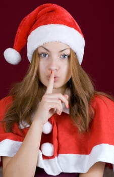 Portrait of a girl in santa clothing that does not want to talk a secret