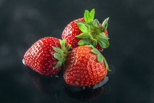 Three fresh strawberries inside water