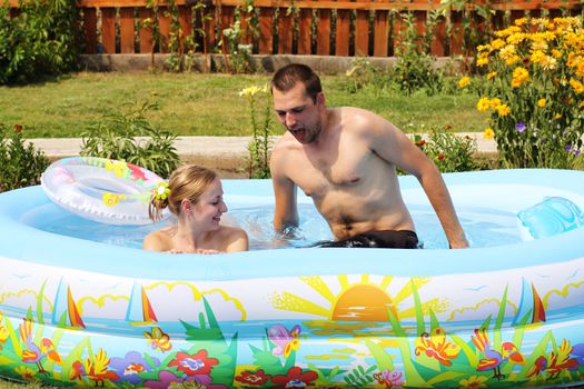 young pair bathes in inflatable pool