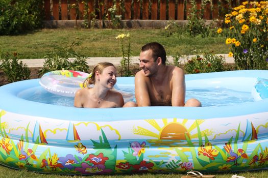 young pair bathes in inflatable pool