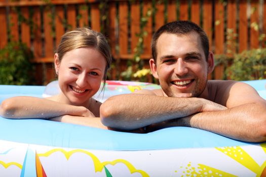 young pair bathes in inflatable pool