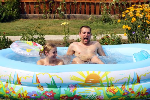 young pair bathes in inflatable pool