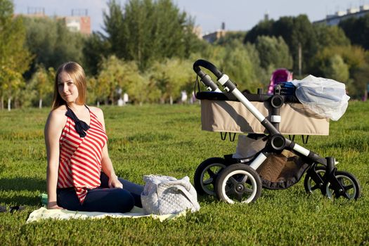 Young mother with baby stroller for a newborn