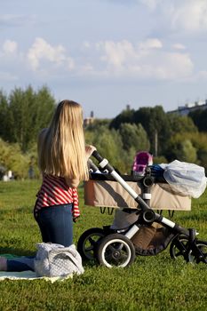 Young mother with baby stroller for a newborn