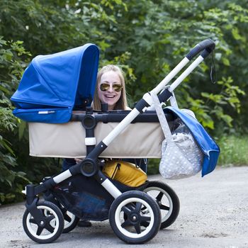 Young mother with baby stroller for a newborn