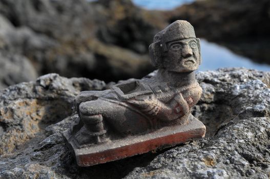 Ancient Maya Statue on the Rocks near the Ocean