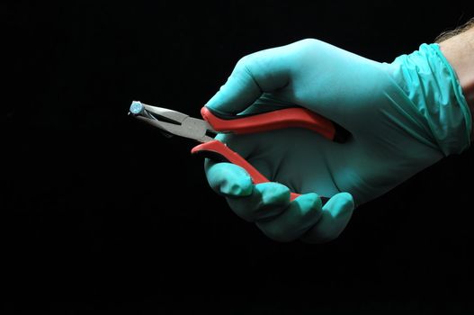 Pliers and a Hand on a Black Background