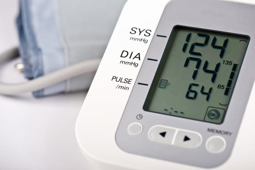 Close-up of digital blood pressure monitor with indicators of measurements on the screen