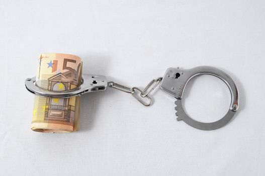Financial Concept Handcuffs and Money on a White Background