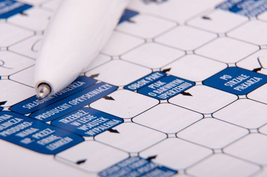 An image of crossword and white pen