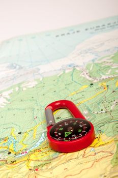 An image of red pocket compass and road map