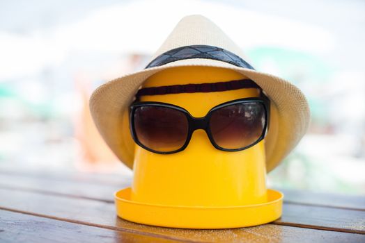 The Beach scene with bucket, hat and sunglasses