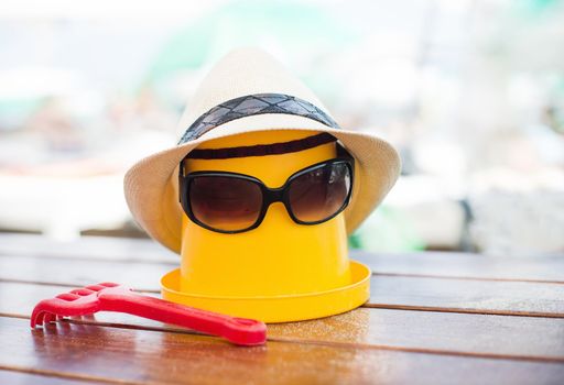 The Beach scene with bucket, hat and sunglasses